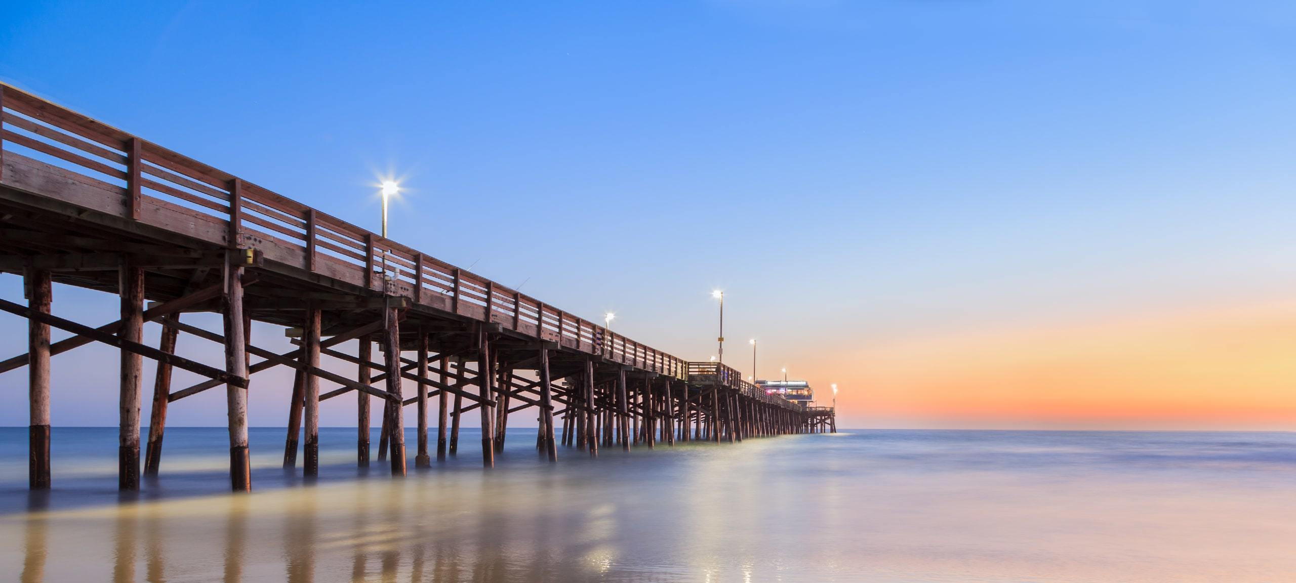 Sunset view of beach and Balboa Pier in Newport Beach